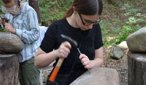 Milana Ljubisavyevic aus Serbien arbeitet den Namen des nach Auschwitz deportierten Eduard Majewski in einen Flussstein ein. (Foto: Michael Hecker, Initiative Gedenkweg Buchenwaldbahn)